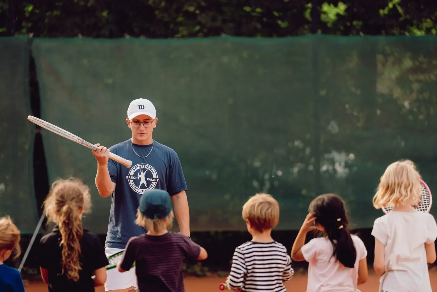 Trainer mit Kindergruppe auf dem Platz